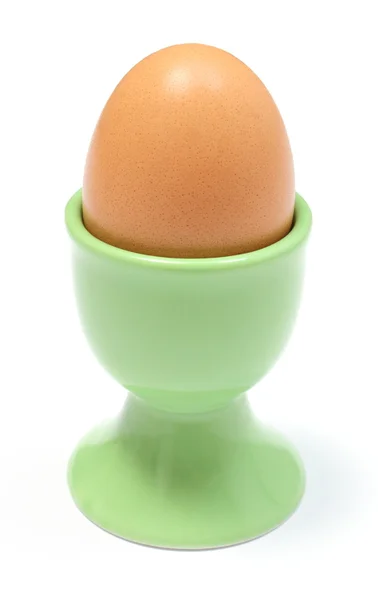 Närbild av kokt ägg i gröna cup. vit bakgrund — Stockfoto