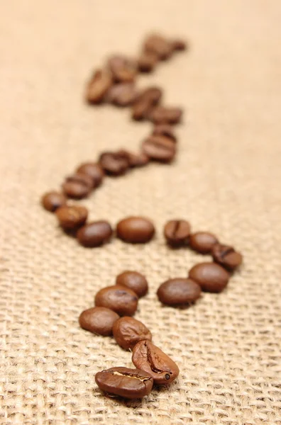 Kaffeekörner auf altem Stoff — Stockfoto