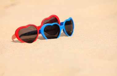 kum üzerinde kalp şeklinde renkli Güneş gözlükleri