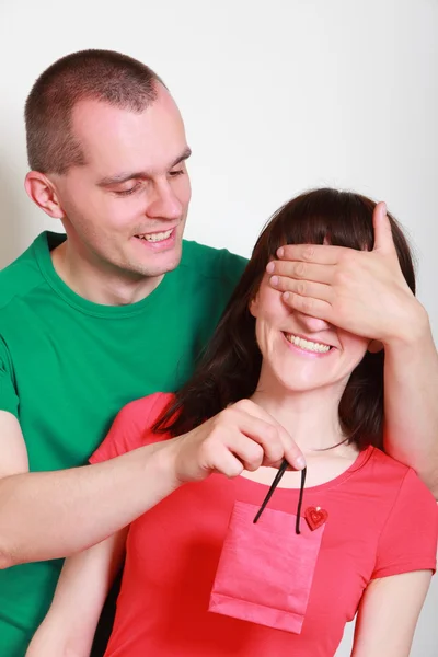 Muž dává dárek překvapen usmívající se žena — Stock fotografie