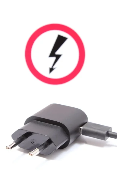 Plugue elétrico e cabo com sinal de perigo de alta tensão — Fotografia de Stock