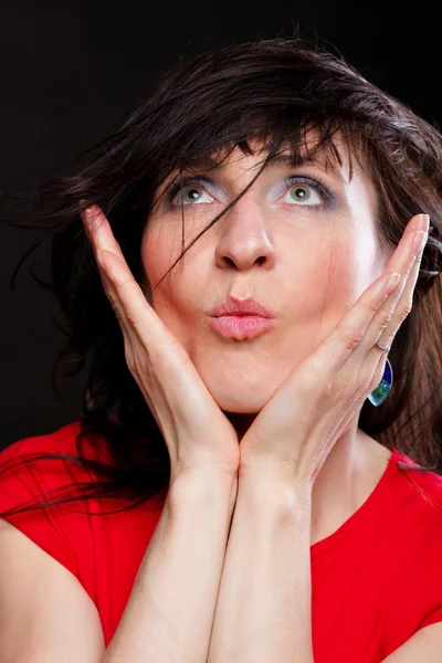 Beautiful woman in red sending kiss — Stock Photo, Image