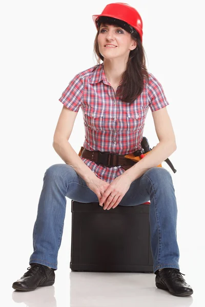Woman in a helmet sits in the tool box — Stock Photo, Image