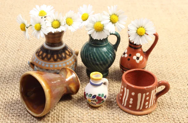 Decorative ceramic vases and white daisies on jute canvas — Stock Photo, Image