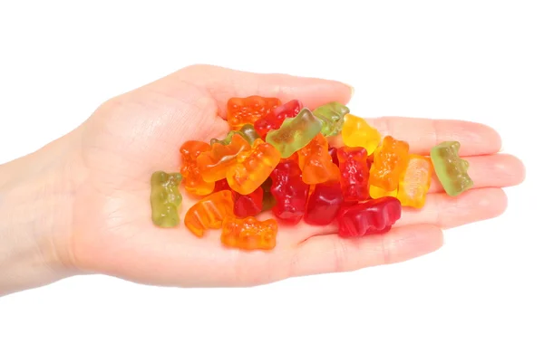Montón de coloridos caramelos haribo oso en la mano de la mujer — Foto de Stock