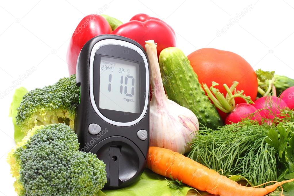 Glucose meter for glucose level and fresh vegetables on wooden cutting board