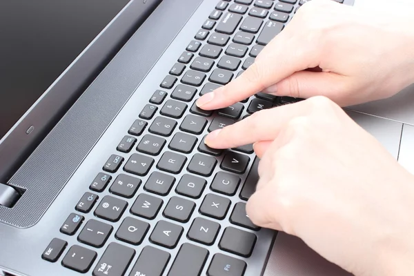 Female hand writing on a laptop keyboard — Stock Photo, Image