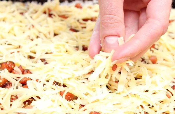 Mão de cozinheiro colocando queijo — Fotografia de Stock