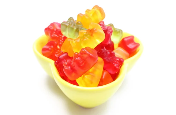 Montón de coloridos caramelos de oso haribo en tazón amarillo. Fondo blanco — Foto de Stock