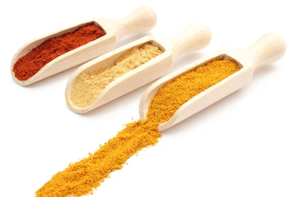 Three spices - curry, ginger and paprika - on wooden spoons — Stock Photo, Image