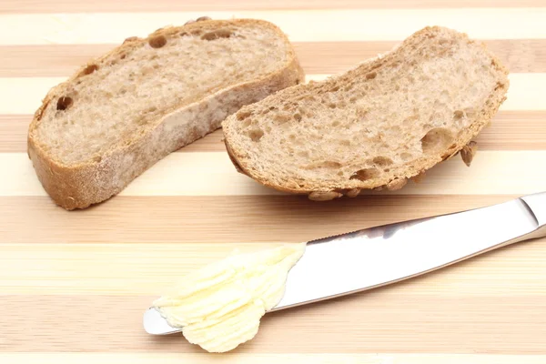 Manteiga sobre faca e fatia de pão — Fotografia de Stock