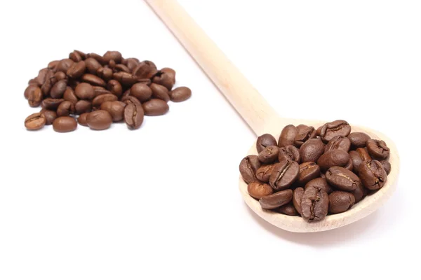 Heap of coffee on wooden spoon. White background — Stock Photo, Image