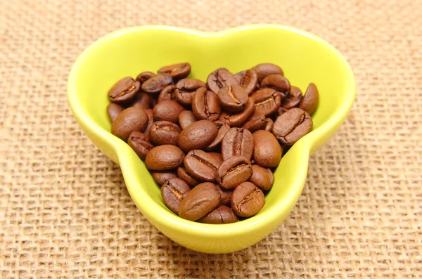 Grains de café en tasse sur toile de jute — Photo