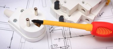 Evin elektrik sigortasında elektrik sigortası olan tornavidalar. İnşaat şemaları, aksesuarlar ve mühendislik işleri için iş aletleri. Ev konsepti inşa ediliyor