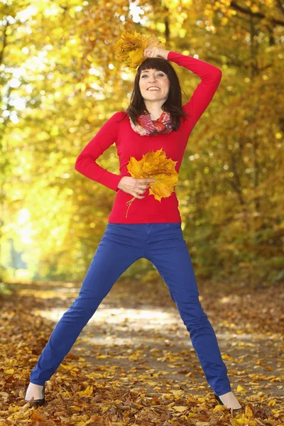 Donna con foglie d'autunno in mano — Foto Stock