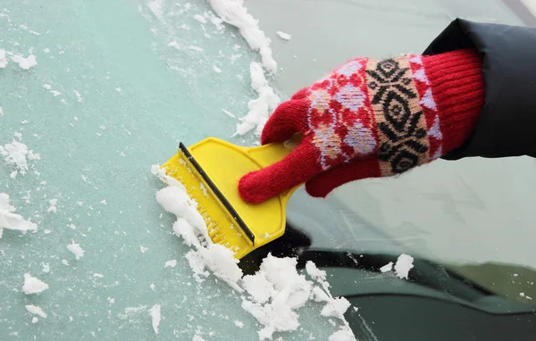 Hand of woman scraping ice from car windscreen — Stock Photo, Image