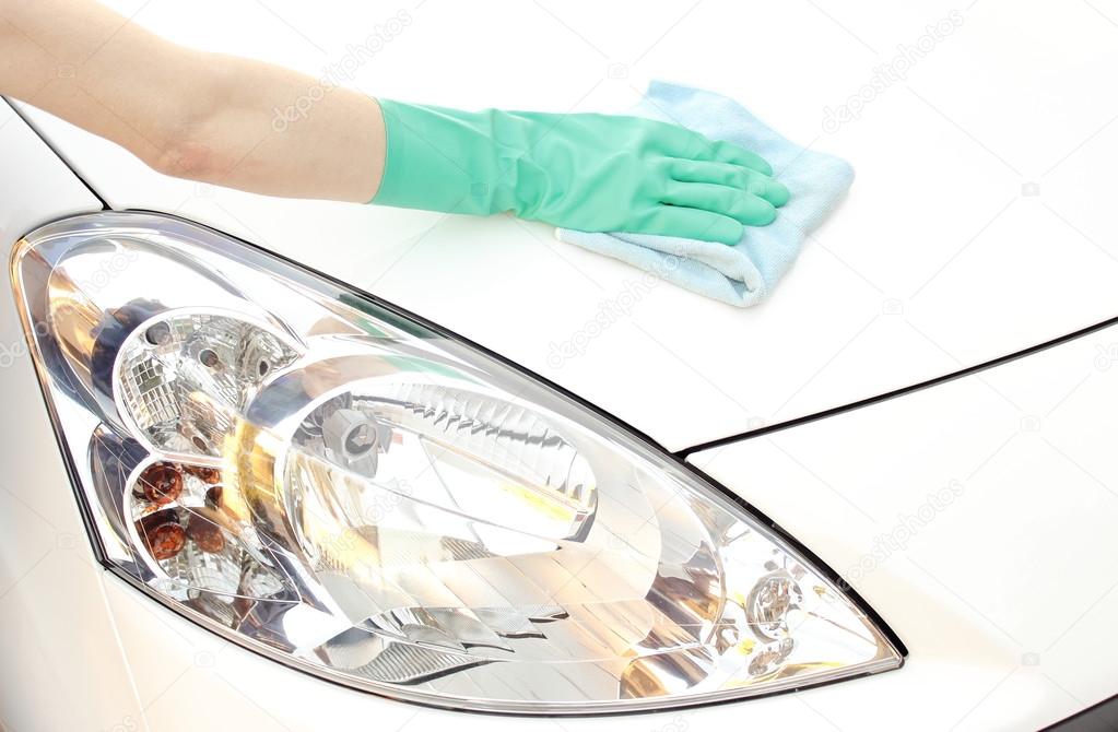 Woman hand with cloth cleaning car