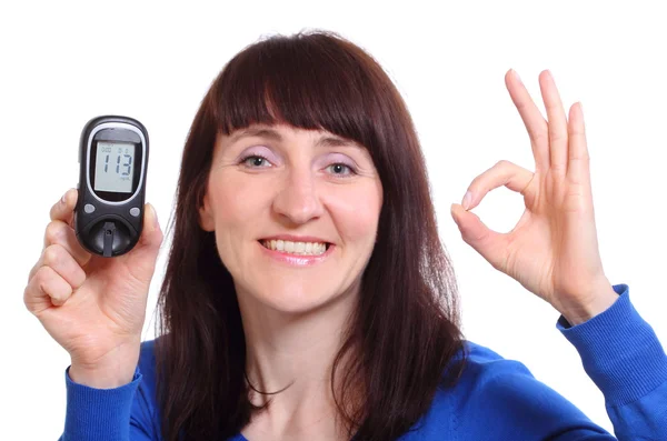 Donna sorridente con misuratore di glucosio su sfondo bianco — Foto Stock