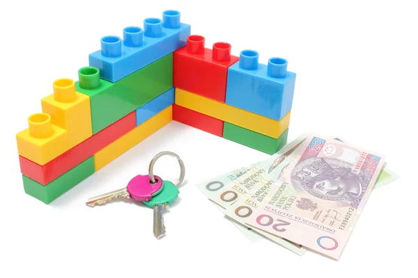 Pared de bloques de construcción coloridos de plástico con llaves caseras y dinero — Foto de Stock