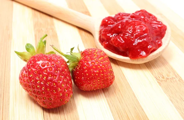 Mermelada de fresa en cuchara de madera con frutas frescas — Foto de Stock