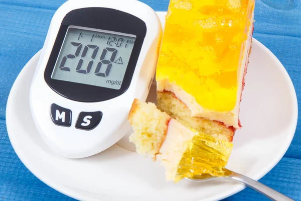 Glucose meter for checking and measuring sugar level and creamy sweet sponge cake with layers and jelly. Nutrition during diabetes. Festive dessert