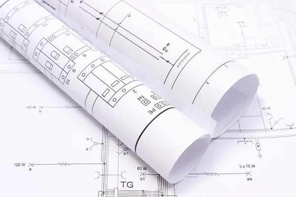 Rolled electrical diagrams on construction drawing of house — Stock Photo, Image