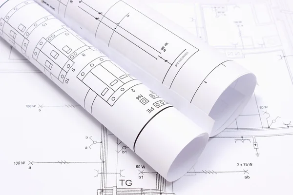 Diagrammi elettrici rotolati su disegno di costruzione di casa — Foto Stock