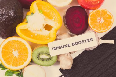 Yazılı bağışıklık güçlendirici, sebzeli taze olgun meyveler ve koruyucu maske. Doğal, sağlıklı vitaminler ve mineraller. Covid-19 zamanlarında faydalı yiyecekler