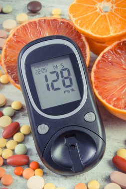 Şeker seviyesini ölçmek için glukometre, taze doğal meyve ve ilaç. Meyve yemekle diyabet sırasında takviye almak arasında seçim yapın.