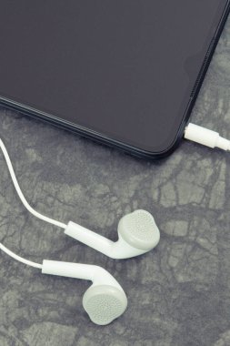 Cep telefonu, kulaklıklı akıllı telefon. Müzikle rahatlama zamanı. Elektronik ekipman kullanılıyor