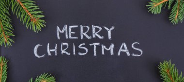 Yazılı Mutlu Noeller ve yeşil ladin dalları. Noel zamanı için dekorasyon