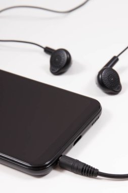 Cep telefonu, kulaklıklı akıllı telefon. Elektronik ekipman kullanarak. Beyaz arkaplan