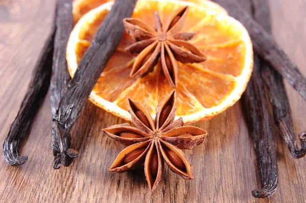 星のアニーゼ 乾燥オレンジのスライス 木製の板に香りの良いバニラスティックポッド 料理やベーキングのための調味料の閉鎖 — ストック写真
