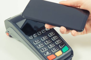 Kredi kartı okuyucu ve cep telefonunu nakit ödemelerde kullanıyor. Ödeme terminali. Finans ve bankacılık kavramı
