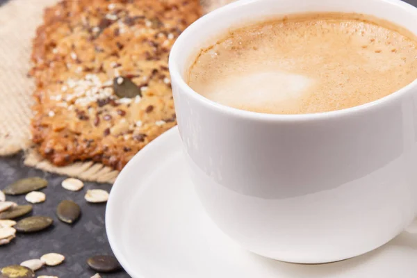 一杯咖啡和新鲜的自制燕麦饼干与蜂蜜和不同的健康种子 美味的脆甜食 — 图库照片