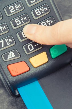 PIN kodunu ödeme terminaline giriş yapan bir kadın eli. Alışveriş için para ödemeden. Kredi kartı okuyucu. Finans kavramı