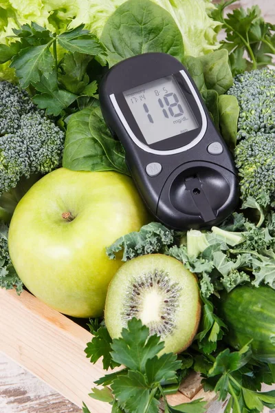 Glucose meter and fresh ripe green fruits with vegetables as healthy food containing natural vitamins. Diabetes and body detox