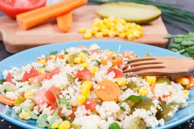 Diyet ve zayıflama için en iyi besleyici gıda olarak kuskus ve sebzeli taze hazırlanmış salata. Kaynak vitaminler ve mineraller