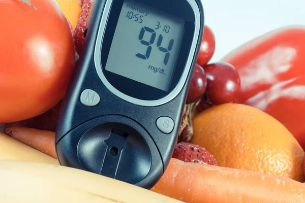 Glucometer with result of measurement sugar level and fresh ripe natural fruits and vegetables. Nutritious food containing healthy minerals and vitamins