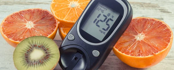 Glucometer with result of sugar level and fresh natural fruits. Diabetes and healthy lifestyle and nutrition