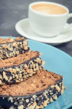 Mavi tabakta kabak ve bir fincan beyaz kahveden yapılmış taze pişmiş hamur işi. Tatlı nefis.
