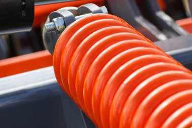 Çelikten yapılmış sert turuncu yay. Büyük endüstriyel ya da tarımsal makinenin bir parçası. Teknoloji