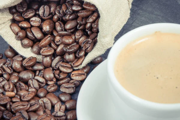 Witte Glazen Kop Koffie Gebrande Donkere Geurige Koffiekorrels Jute Zak — Stockfoto