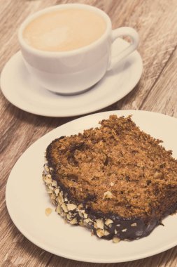 Kabaktan yapılmış taze fırınlanmış hamur işi ve bir fincan beyaz kahve. Lezzetli tatlı. Ahşap arka plan. Vintage fotoğraf