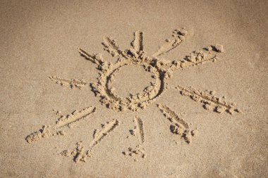 Kumsalda kumdaki güneşin şekli. Yaz ve tatil zamanı kavramı