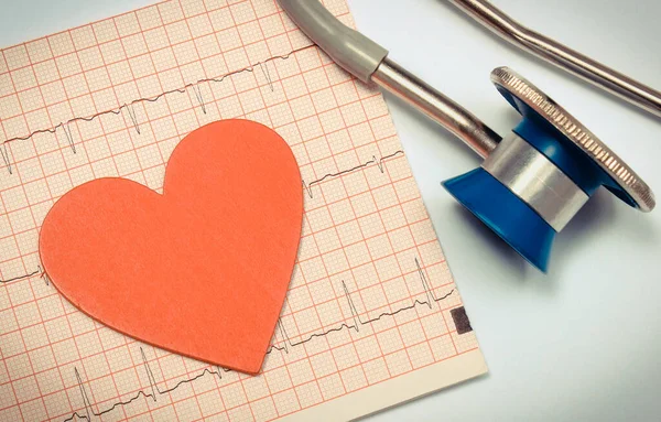 Medizinisches Stethoskop Und Rote Herzform Liegen Auf Einem Elektrokardiogramm Diagramm — Stockfoto