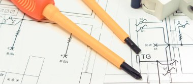 Evin elektrik sigortasında elektrik sigortası olan tornavidalar. İnşaat şemaları, aksesuarlar ve mühendislik işleri için iş aletleri. Ev konsepti inşa ediliyor