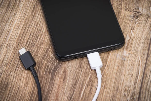 Smartphone with charger cables. Mobile phone charging concept