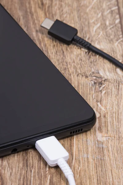 Smartphone Negro Con Cables Cargador Sobre Fondo Madera Concepto Carga — Foto de Stock