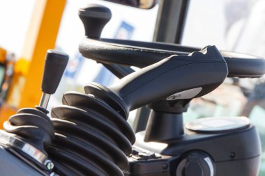 Tarımsal ya da endüstriyel makinede düğmeleri ve direksiyonu olan kontrol paneli. Aracın ayrıntıları